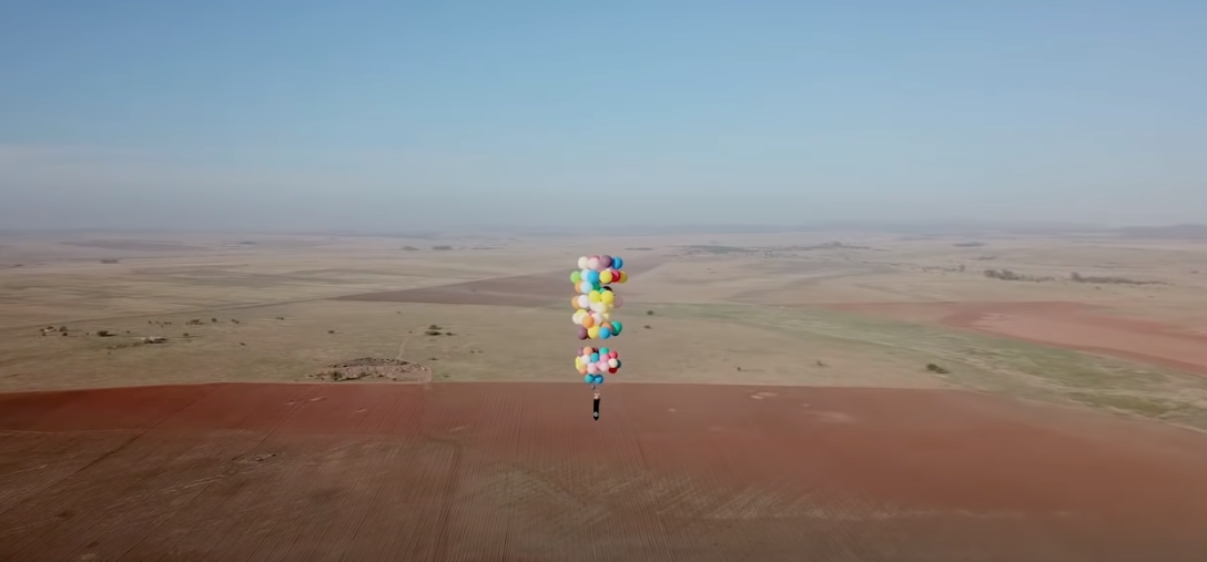 Száz darab lufival a székéhez kötözve az egekbe emelkedett egy férfi, 25 kilométert repült – videó